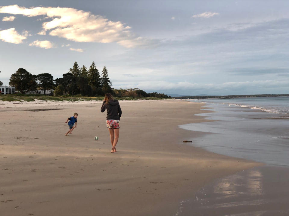 Mum and her son playing football on the beach