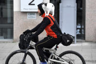 FILE - A man rides a bicycle with a cat on his shoulder in the center of Brussels, Friday, March 3, 2023. In 2010, the study says, only 3.5% of all trips in the city were made by bicycle. By early 2022, that share had increased to an estimated 10%. The number of bicycle trips caught by counters rose 60% in 2020 and 20% in 2021. (AP Photo/Geert Vanden Wijngaert, File)