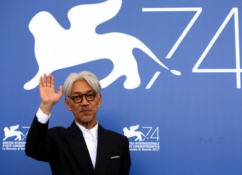 FILE PHOTO: Japanese musician and composer Sakamoto waves during a photocall for the movie "Ryuichi Sakamoto: Coda" at the 74th Venice Film Festival in Venice