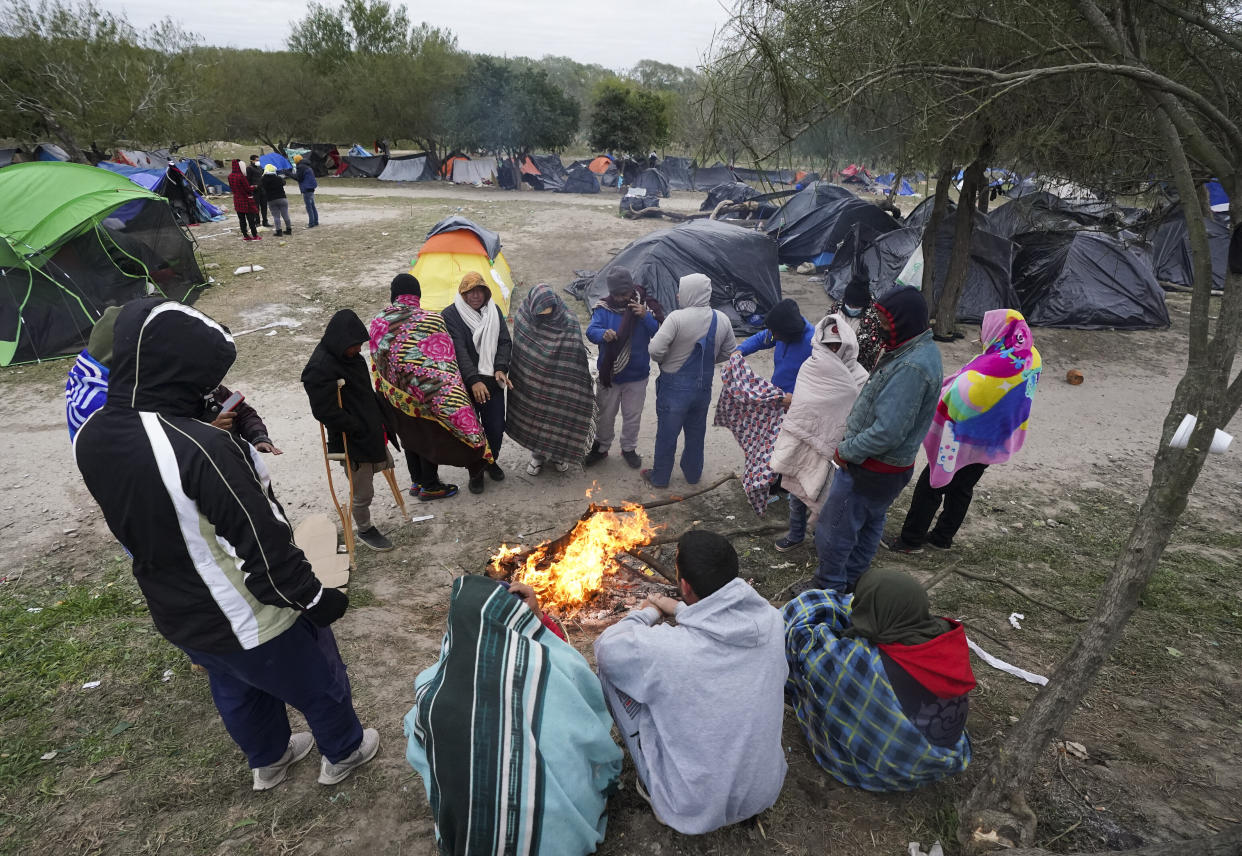 FILE - Migrants stand in the cold weather around a campfire at a makeshift camp on the U.S.-Mexico border in Matamoros, Mexico, Dec. 23, 2022, as they wait on a pending U.S. Supreme Court decision on asylum restrictions. The Biden administration on Thursday, Jan. 5, said it would immediately begin turning away Cubans, Haitians and Nicaraguans who cross the U.S.-Mexico border illegally, a major expansion of an existing effort to stop Venezuelans attempting to enter the U.S. (AP Photo/Fernando Llano, File)