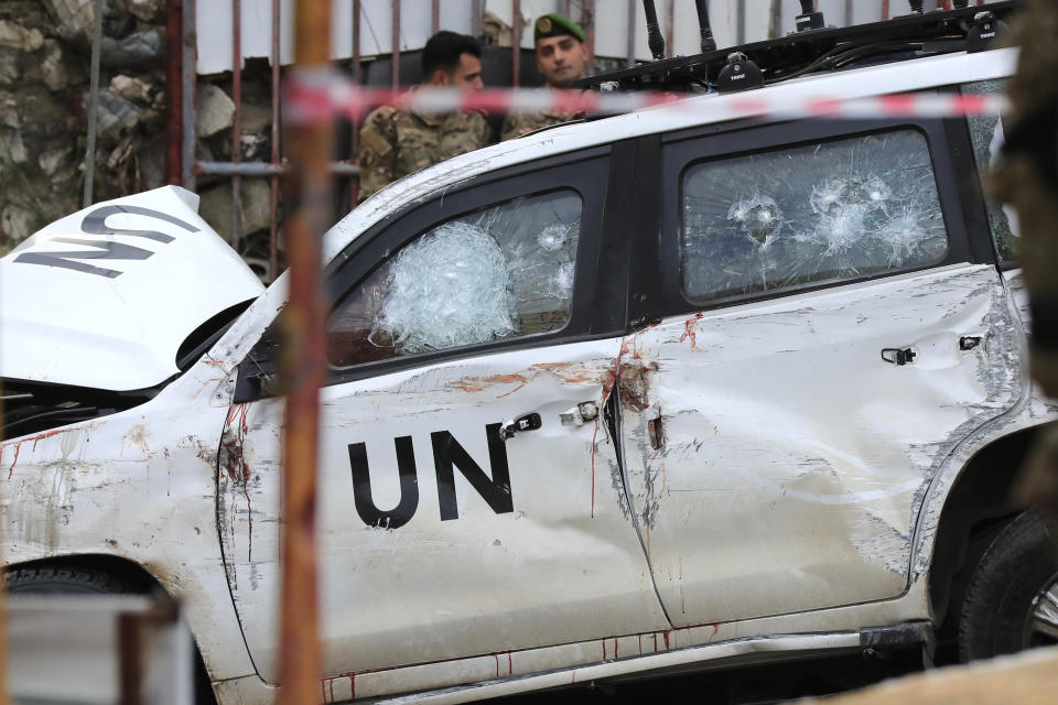 FILE - Lebanese soldiers stand behind a damaged vehicle after a UN peacekeepers convoy came under fire in the Al-Aqbiya village, south Lebanon, Thursday, Dec. 15, 2022. Lebanon's military tribunal has released a man accused of killing an Irish United Nations peacekeeper almost a year ago on bail, security and judicial officials said Wednesday, Nov. 15, 2023. (AP Photo/Mohammed Zaatari, File)
