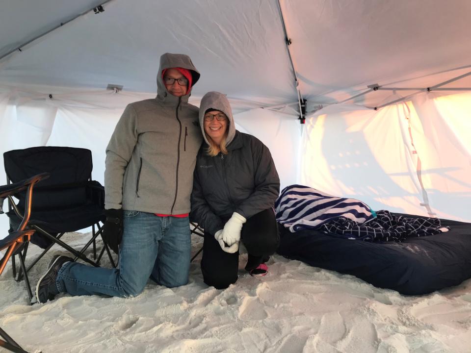Matt and Jenny Reed smile for a photo as their son Alex, 6, sleeps behind them in a  tent the family set up at Pensacola Beach shortly after arriving at 4:45 a.m. Friday, Nov. 6, 2021, to snag a spot for the Blue Angels Homecoming Air Show.
