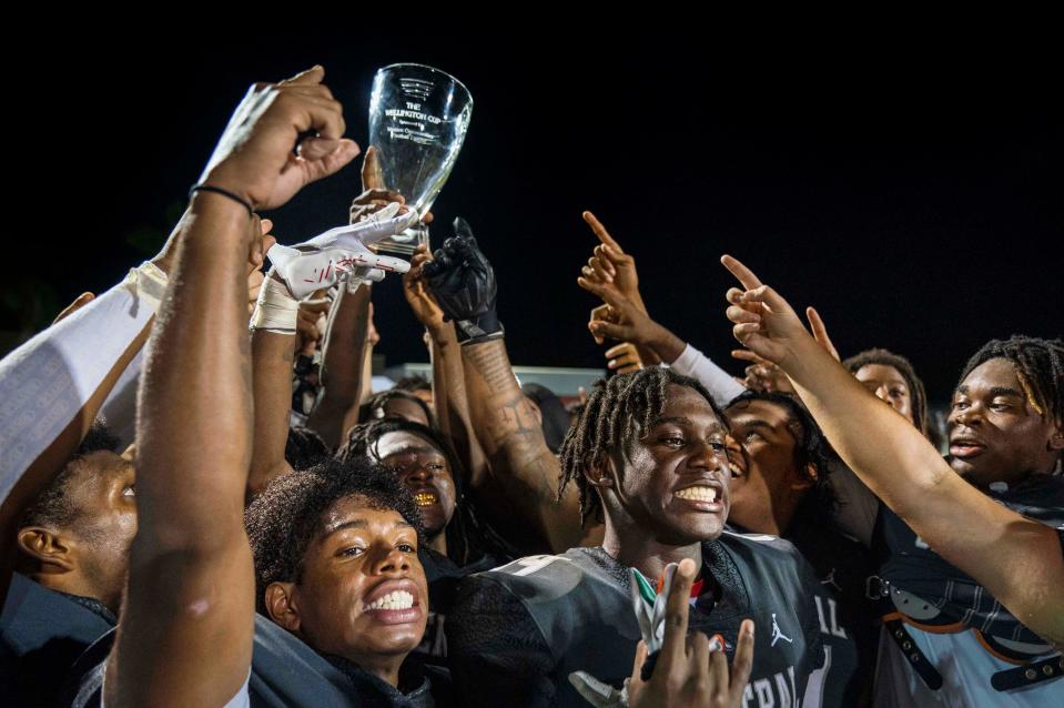 Palm Beach Central players hoist the Wellington Cup after his team beat Wellington High School 41-14  in Wellington, Florida on October 28, 2022.