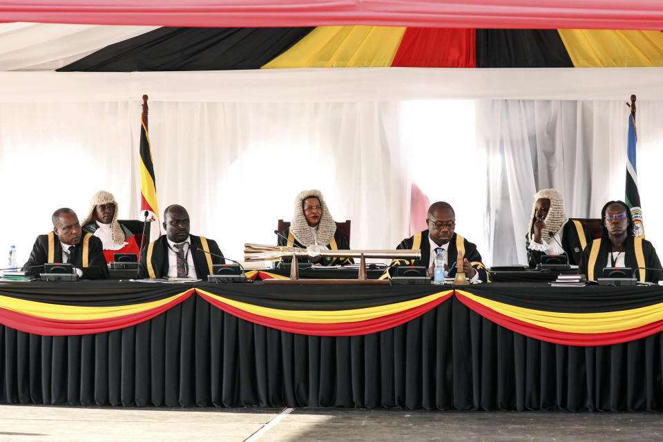 FILE - Speaker of the Parliament of Uganda Anita Among, center, listens to Ugandan President Yoweri Museveni, as he delivers a 'State of the Nation' address at Kololo independence grounds in Kampala, Uganda, Wednesday, Feb 14, 2024. The United States on Thursday imposed sanctions on Uganda's parliamentary speaker and other officials over alleged corruption and serious abuses of human rights. Speaker Anita Among has been sanctioned "due to involvement in significant corruption tied to her leadership" of the national assembly, a State Department statement said. (AP Photo/Hajarah Nalwadda, File)