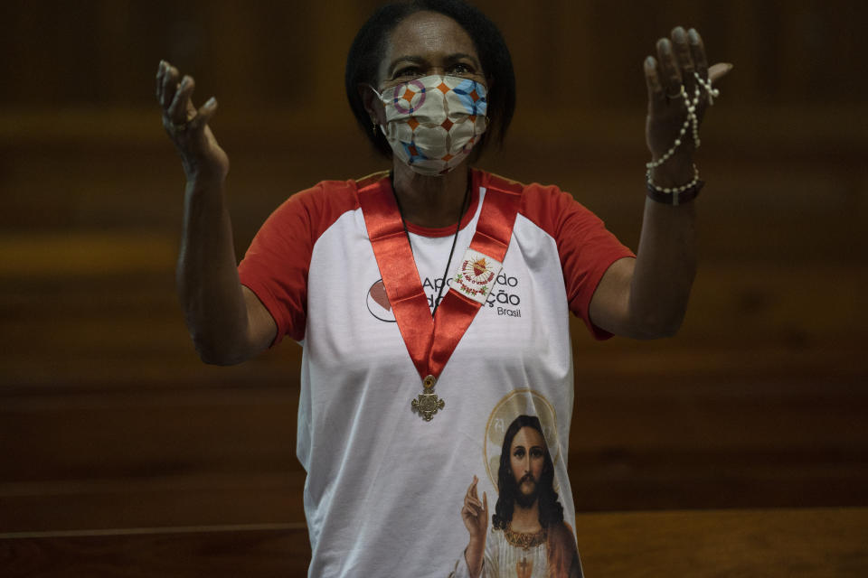 A woman wearing a protective face mask stands in prayer during a Mass at the Metropolitan Cathedral, in Rio de Janeiro, Brazil, Saturday, July 4, 2020. Following an easing of restrictions related to COVID-19, the Catholic church in Rio celebrated its first Mass with 30% of its worshippers, while observing preventive measures to avoid spreading the new coronavirus. (AP Photo/Leo Correa)