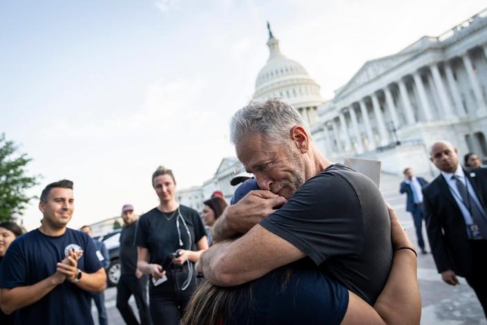 Jon Stewart hugs Rosie Torres,&nbsp;wife of veteran Le Roy Torres who suffers from illnesses related to his exposure to burn pits in Iraq, after the Senate passed the PACT Act on 2 August  (Getty Images)