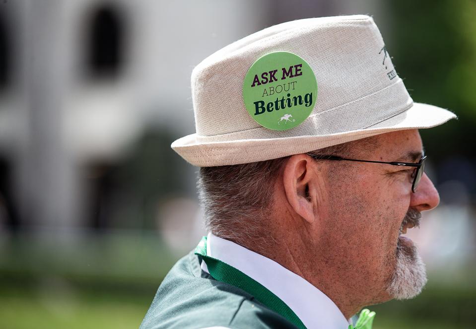 Greg Burke talks with a patron between races near the Rolex clock on the Keenland grounds on Thursday afternoon. Burke is one of several 'Betologists' on staff that help racegoers get the most of their experience by offering betting advice, directions around the track and a familiar, welcoming smile. April 21, 2023