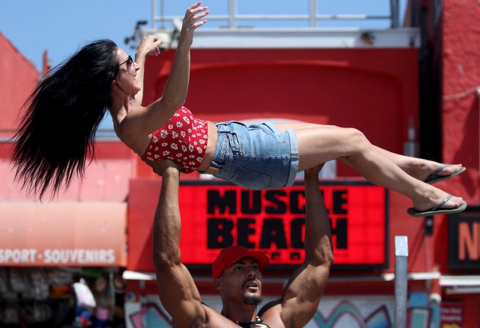 Bodybuilder Ike Catcher lifts a woman at Muscle Beach in Venice on Saturday.