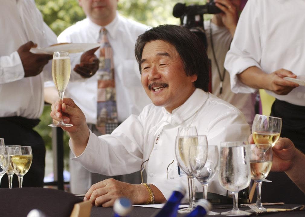 The Iron Chef, Sakai Hiroyuki, sits on a panel of judges at a competion.