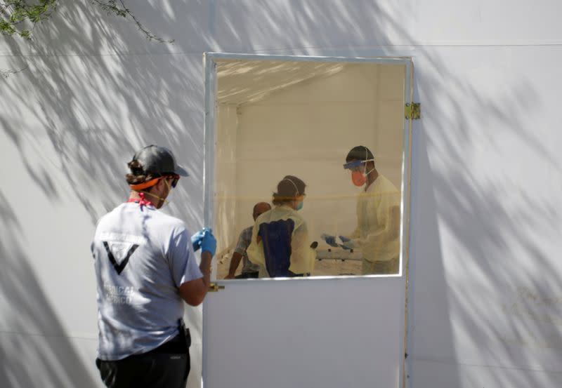 FILE PHOTO: Medical staff from Global Response Management takes samples from a patient suspected of contracting coronavirus disease (COVID-19) at an isolation area of a hospital installed at a migrant encampment in Matamoros