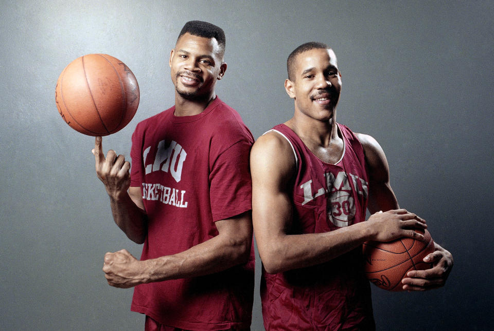 FILE - Loyola Marymount basketball teammates Hank Gathers, left, and Bo Kimble pose together before practice at the university's gym in Los Angeles, Feb. 15, 1990. Loyola Marymount suffered an unspeakable tragedy in the 1990 West Coast Conference tournament when burly forward Hank Gathers collapsed on the court and later died of heart condition. Playing while grieving, Bo Kimble scored 45 points against New Mexico State in the opening round of the NCAA Tournament and led the Lions to the Elite Eight as a No. 11 seed. (AP Photo/Douglas C. Pizac, File)