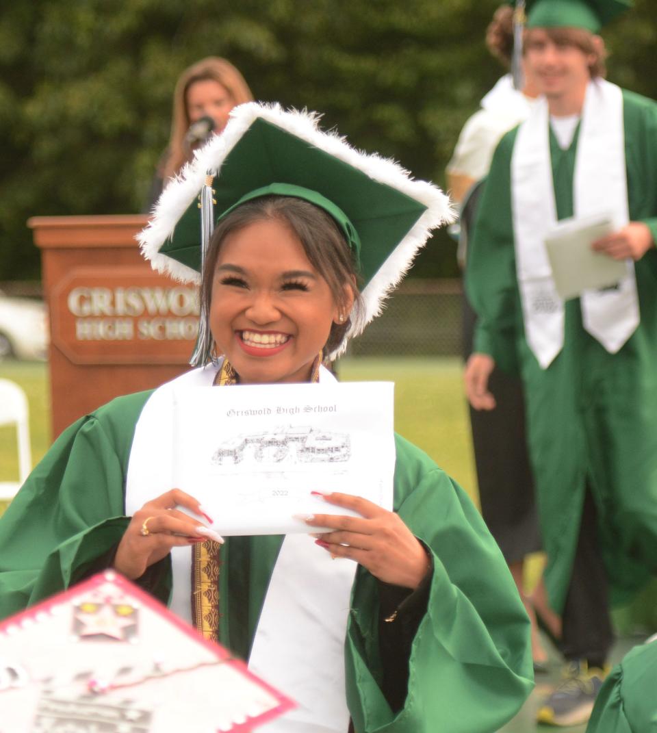 Griswold High School graduate Skylah Phanthorath holds her diploma for family and friends to see Wednesday at outdoor commencement exercises at the school. There were 120 total graduates.