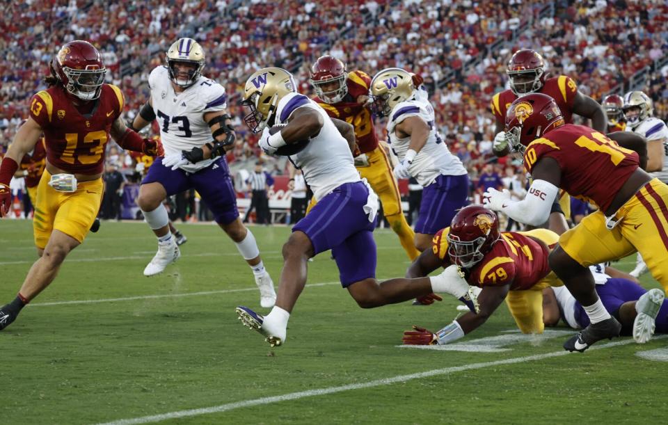 Washington running back Dillon Johnson runs through a hole in the USC defense during the first half.