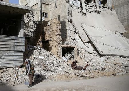 An old man walks near a damaged building in the besieged town of Douma in eastern Ghouta in Damascus, Syria, March 1, 2018. REUTERS/ Bassam Khabieh