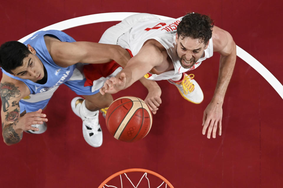 Argentina's Gabriel Deck, left, fights for a rebound with Spain's Pau Gasol during a men's basketball preliminary round game at the 2020 Summer Olympics, Thursday, July 29, 2021, in Saitama, Japan. (Aris Messinis/Pool Photo via AP)