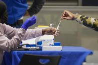 A travelers places a swab in a tube after self testing for COVID-19 at a NYC Health + Hospitals mobile testing site, Tuesday, Nov. 24, 2020, in New York's Penn Station. Gov. Andrew Cuomo urged New Yorkers to just say no to Thanksgiving gatherings to help reduce COVID-19 infections and hospitalizations, which he said are rising at a dangerous level. (AP Photo/Mary Altaffer)