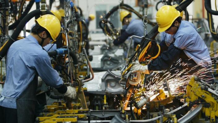 Employees on the assembly line produce cars in Haikou, China.