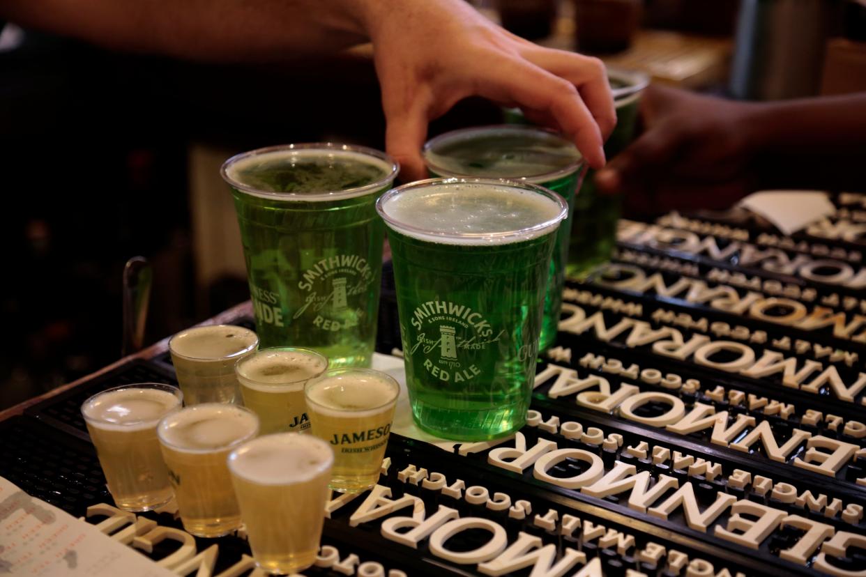 Shots and green beers keep the bartenders busy at Nicholson's Tavern & Pub in downtown Cincinnati on Wednesday, March 17, 2021.