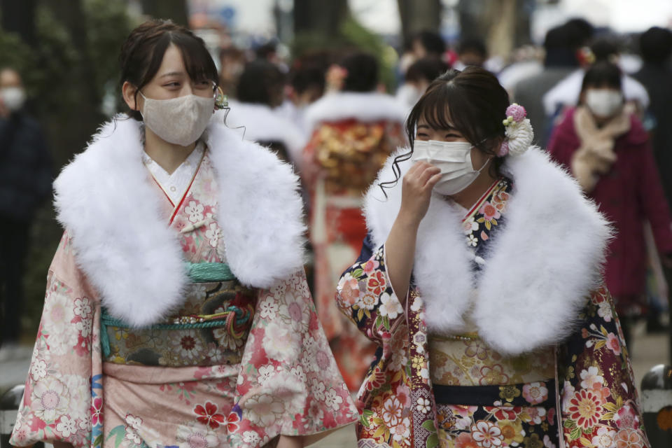 Kimono-clad women wearing face masks to protect against the spread of the coronavirus walk together following a Coming-of-Age ceremony in Yokohama, near Tokyo, Monday, Jan. 11, 2021. The Tokyo area has been under a state of emergency since Friday to try to stop the spread of the virus. (AP Photo/Koji Sasahara)