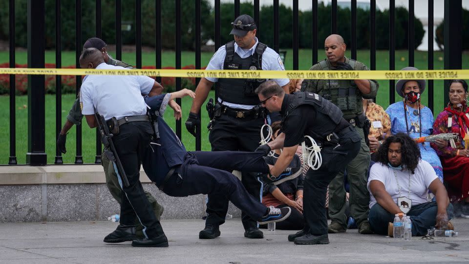 A demonstrator is detained and carried by members of the US Secret Service and US Park Police during an Indigenous Peoples' Day protest in Washington on October 11, 2021. - Sarah Silbiger/Reuters