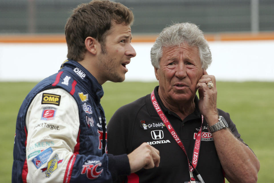 FILE - Marco Andretti, left, talks with Mario Andretti before IndyCar practice laps in Detroit, in this Friday, June 1, 2012, file photo. Marco Andretti made the decision at the start of this year to step away from full-time racing and essentially end three generations of the most famous family in motorsports competing at the highest level. (AP Photo/Dave Frechette, File)