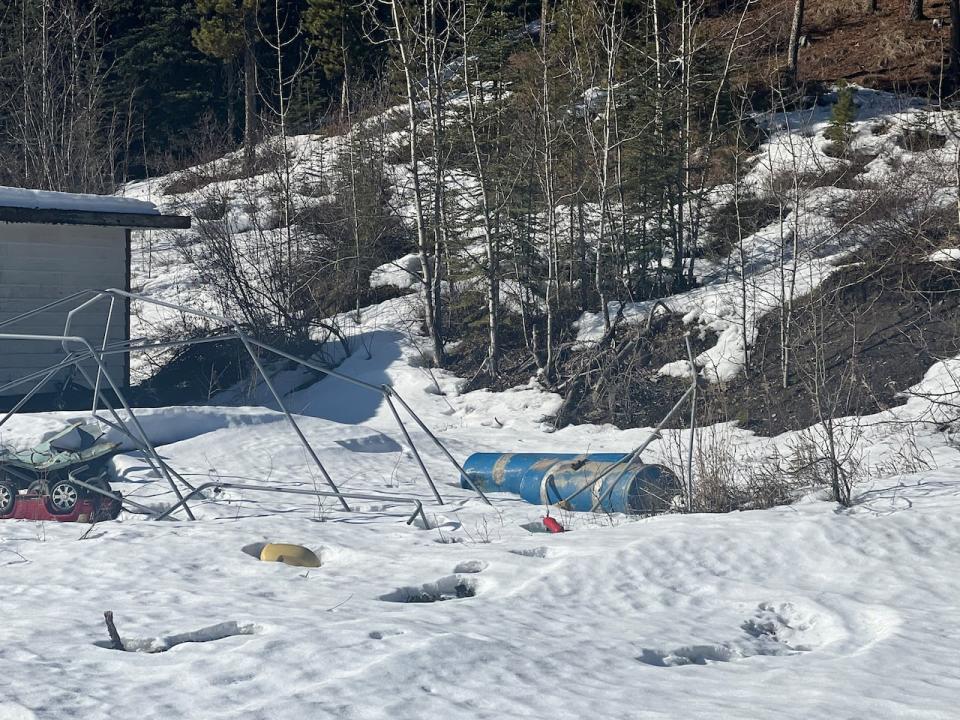 Building rubble, oil drums, unused vehicles and children's toys emerge from the melting snow on the Lodgepole Lane property.  