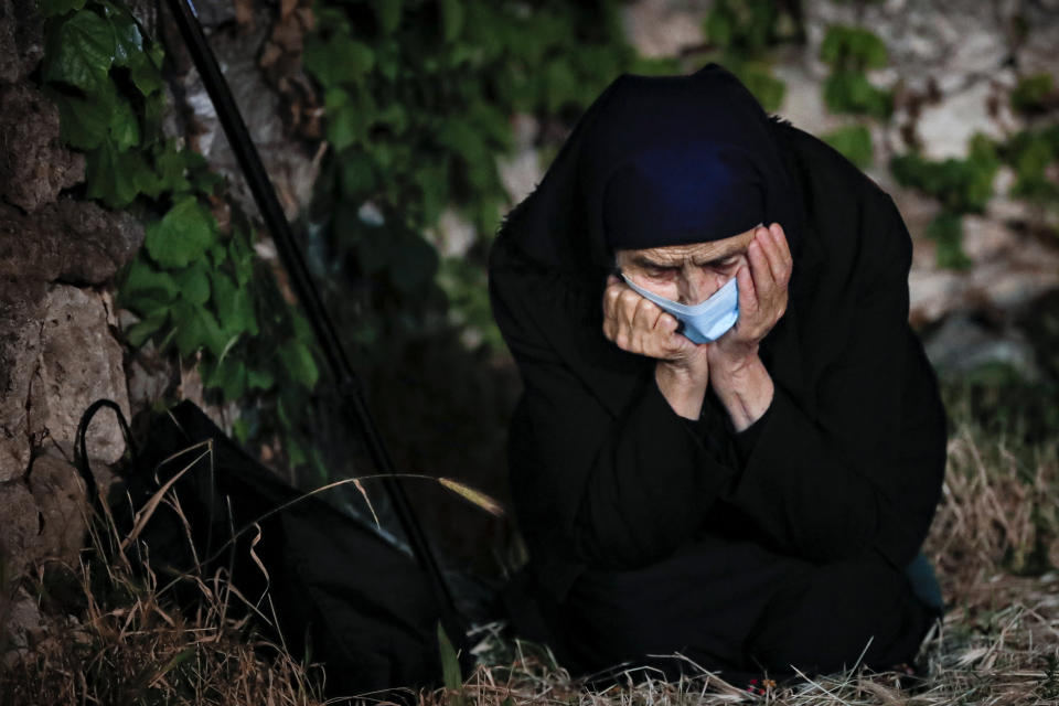 An orthodox worshiper kneels during a religious service in the Black Sea port of Constanta, Romania, late Tuesday, May 26, 2020. (AP Photo/Vadim Ghirda)