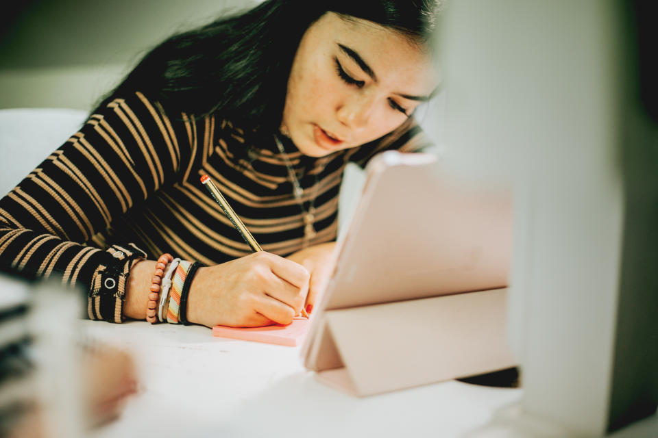 female teenager studying at home and e-learning