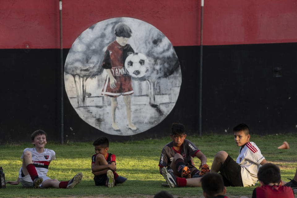 Children relax during a training in a football school at Newell's All Boys club, where Lionel Messi played as a kid in Rosario, Argentina, Wednesday, Dec.14, 2022. (AP Photo/Rodrigo Abd)