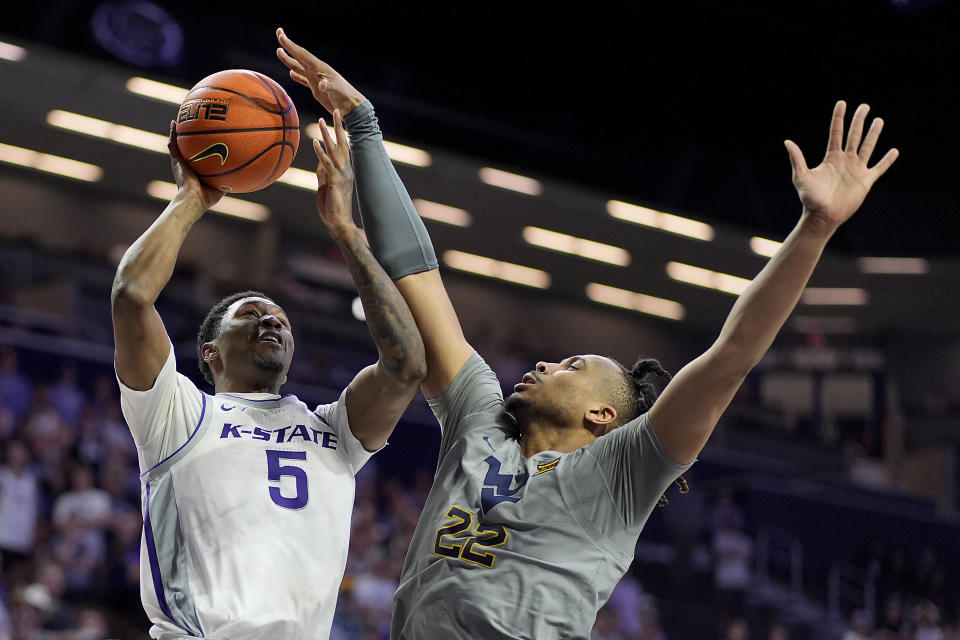 Kansas State guard Cam Carter (5) shoots under pressure from West Virginia forward Josiah Harris (22) during the second half of an NCAA college basketball game Monday, Feb. 26, 2024, in Manhattan, Kan. (AP Photo/Charlie Riedel)