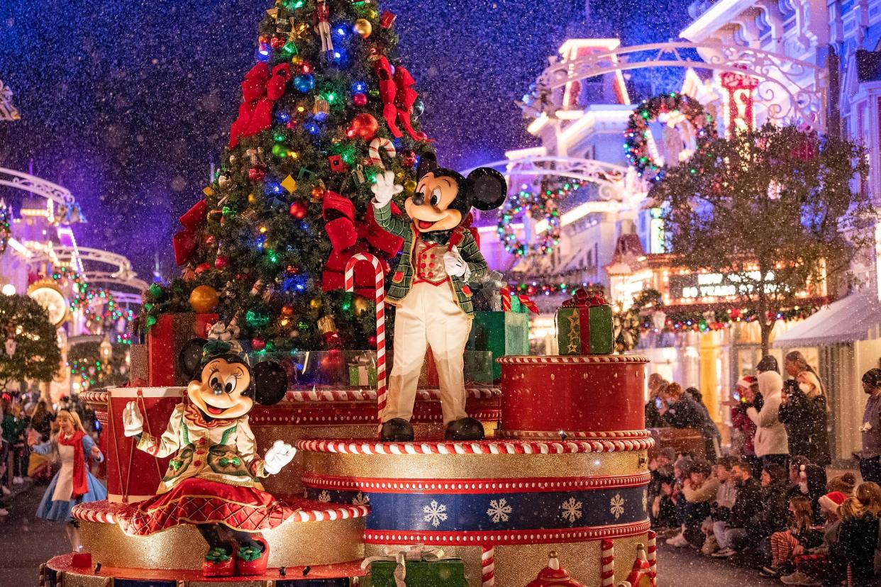 Mickey and Minnie wave to guests as snow appears to along Magic Kingdom's Main Street U.S.A.