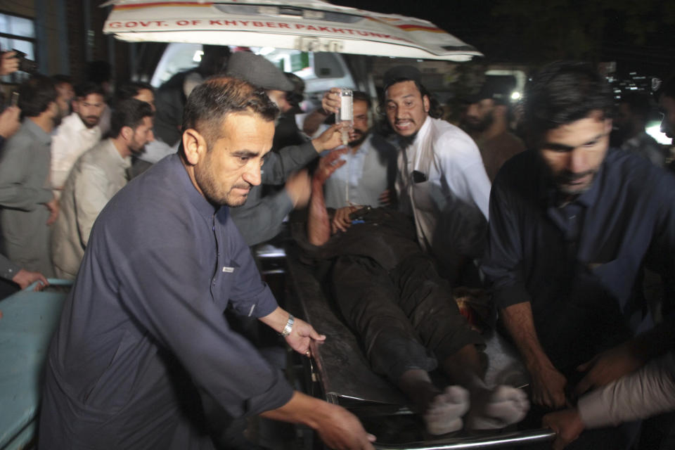 Volunteers unload an injured victim of a bomb blast upon arrival at a hospital, in Saidu Sharif, main town of Pakistan's Swat Valley, Monday, April 24, 2023. Two explosions Monday at a counterterrorism police facility in northwest Pakistan killed few people and wounded dozens, police said. (AP Photo/Naveed Ali)