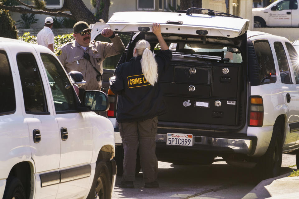 Authorities talk near the home of Bishop David O'Connell in Hacienda Heights, Calif., Sunday, Feb. 19, 2023. O'Connell was shot and killed Saturday just blocks from a church, a slaying of a longtime priest hailed as a "peacemaker" that's stunned the Los Angeles religious community, authorities said. Detectives are investigating the death as a homicide, according to the Los Angeles County Sheriff's Department. (AP Photo/Damian Dovarganes)