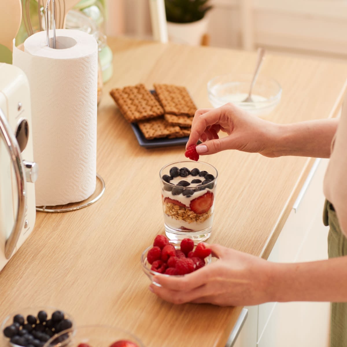 woman making yogurt parfait for breakfast