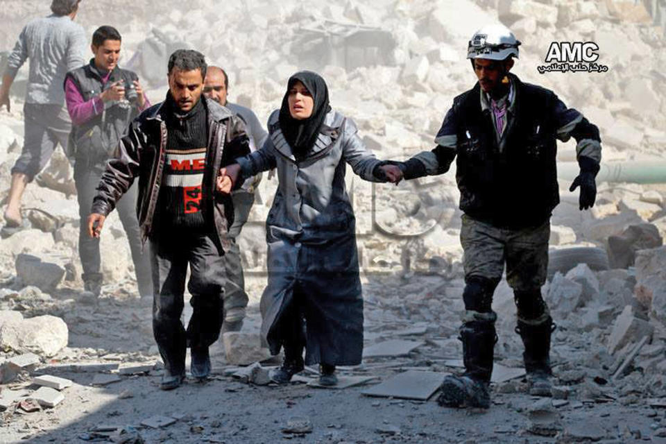 This photo provided by the anti-government activist group Aleppo Media Center (AMC), which has been authenticated based on its contents and other AP reporting, shows Syrian men helping a survivor out of a destroyed building after a Syrian forces warplanes attacked Masaken Hanano neighborhood, in Aleppo, Syria, Monday, Feb. 17, 2014. The Western-backed Free Syrian Army has appointed a new military chief, opposition groups announced Monday as they try to restructure a rebel movement that has fallen into disarray as it faces rampant infighting and declining international support for its fight to topple President Bashar Assad. (AP Photo/Aleppo Media Center, AMC)