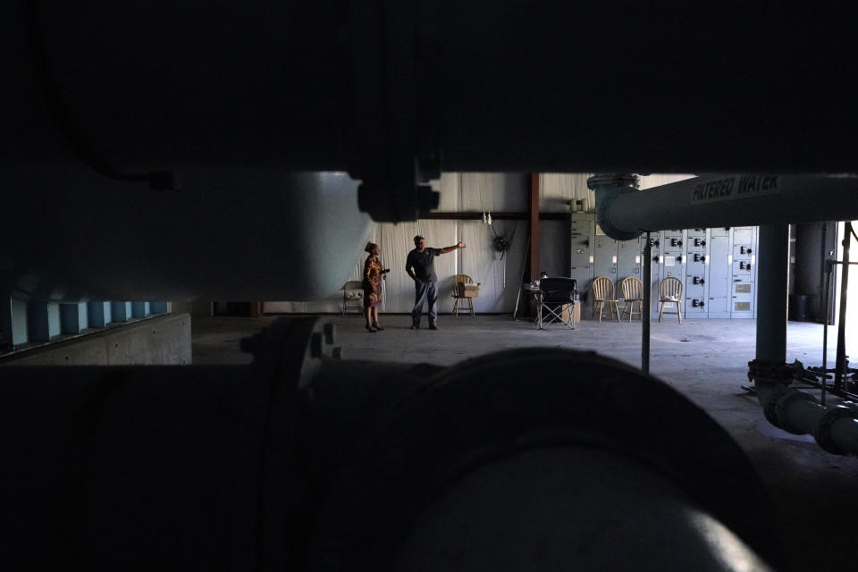 Deborah Elaine-Jones, tax clerk for the Town of Ferriday, talks with water plant operator Mike Gandy inside the newer water plant facility in Ferriday, La., Tuesday, Sept. 13, 2022. In many places, people struggle to find water or else drink water that isn't clean. (AP Photo/Gerald Herbert)