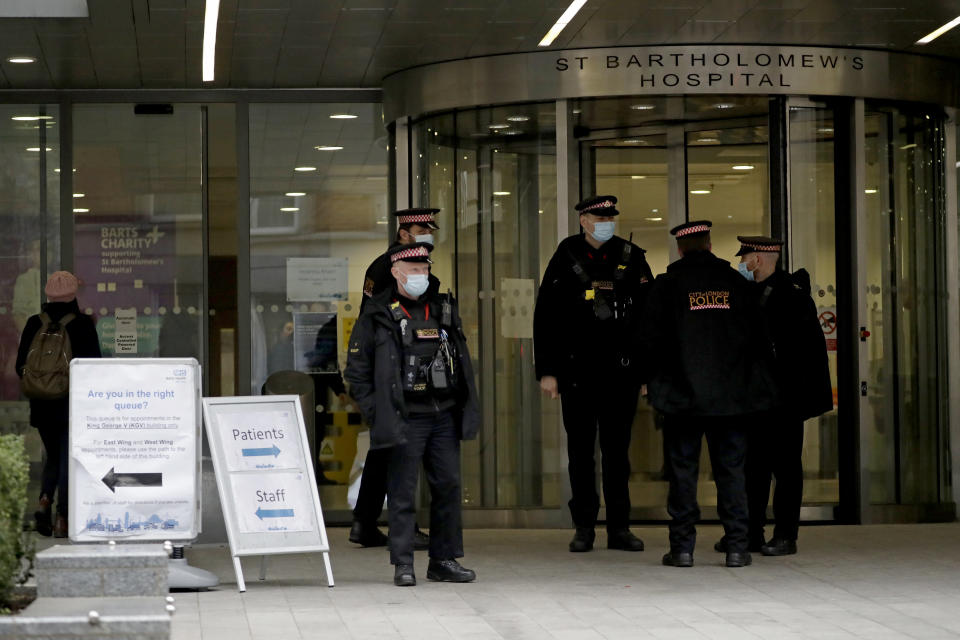 Police officers stand outside the main entrance of St Bartholomew's Hospital in London, where Britain's Prince Philip is being treated, Wednesday, March 3, 2021. Buckingham Palace said Philip, the 99-year-old husband of Queen Elizabeth II, was transferred from King Edward VII's Hospital to St Bartholomew's Hospital on Monday to undergo testing and observation for a pre-existing heart condition as he continues treatment for an unspecified infection. (AP Photo/Matt Dunham)