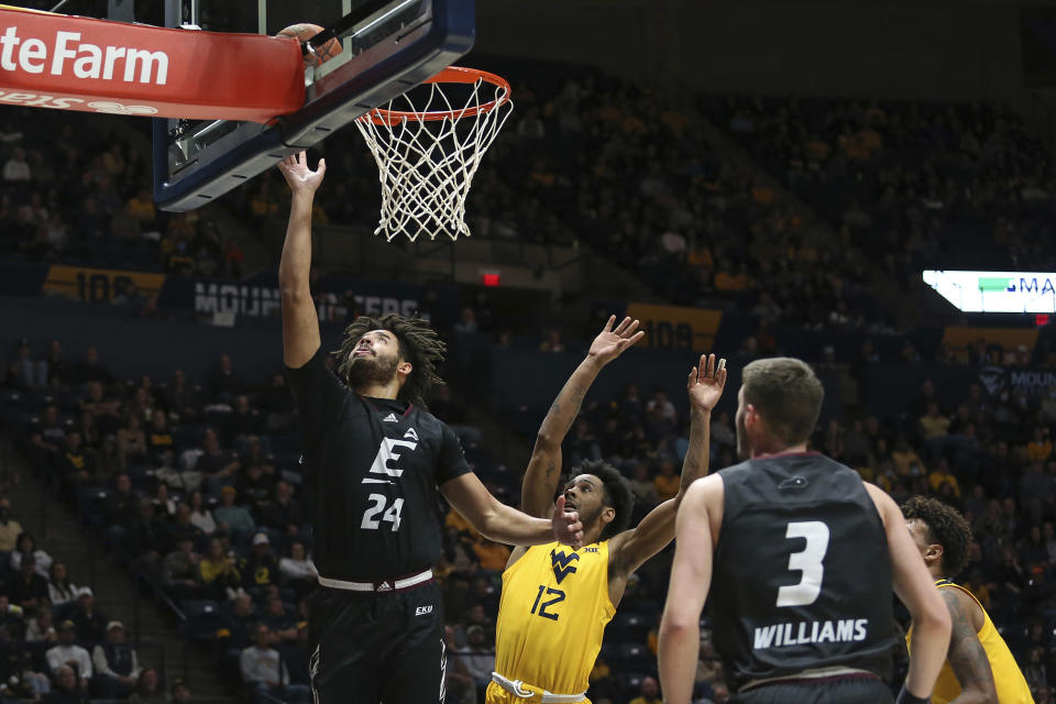 Eastern Kentucky forward Michael Moreno (24) shoots while defended by West Virginia guard Taz Sherman (12) during the first half of an NCAA college basketball game in Morgantown, W.Va., Friday, Nov. 26, 2021. (AP Photo/Kathleen Batten)