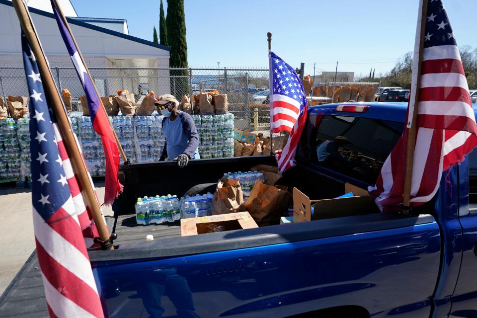 Food and water are loaded into the back of a pickup truck at a distribution site on Feb. 22, 2021, in Houston. The city's boil-water notice has been rescinded however many residents lack water at home due to broken pipes.