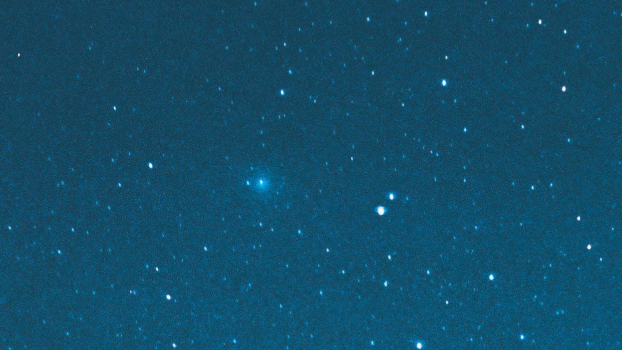  a blue-green comet in the night sky 