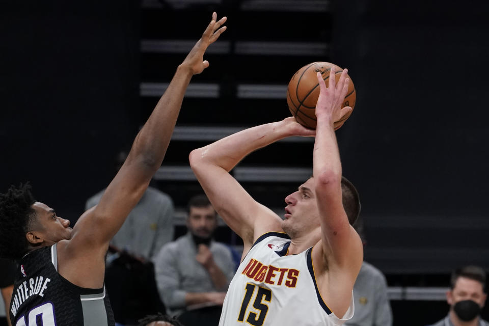 Sacramento Kings center Hassan Whiteside, left, tries to block the shot of Denver Nuggets center Nikola Jokic during the first half of an NBA basketball game in Sacramento, Calif., Saturday, Feb. 6, 2021. (AP Photo/Rich Pedroncelli)