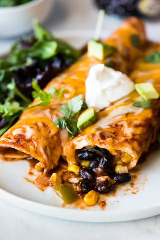 <p>Black bean enchiladas filled with a mixture of black beans, corn, onions and bell peppers, and topped with a red enchilada sauce and melted cheese.</p><p><strong>Get the recipe: <a href="https://www.isabeleats.com/black-bean-enchiladas/" rel="nofollow noopener" target="_blank" data-ylk="slk:Black Bean Enchiladas;elm:context_link;itc:0;sec:content-canvas" class="link rapid-noclick-resp">Black Bean Enchiladas</a></strong></p>