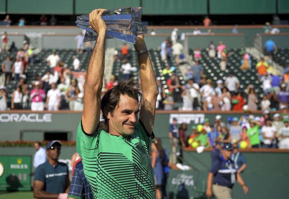 Roger Federer, of Switzerland, celebrates with the trophy after his win against Stanislas Wawrinka, of Switzerland, in the finals of the BNP Paribas Open tennis tournament, Sunday, March 19, 2017, in Indian Wells, Calif. (AP Photo/Mark J. Terrill)