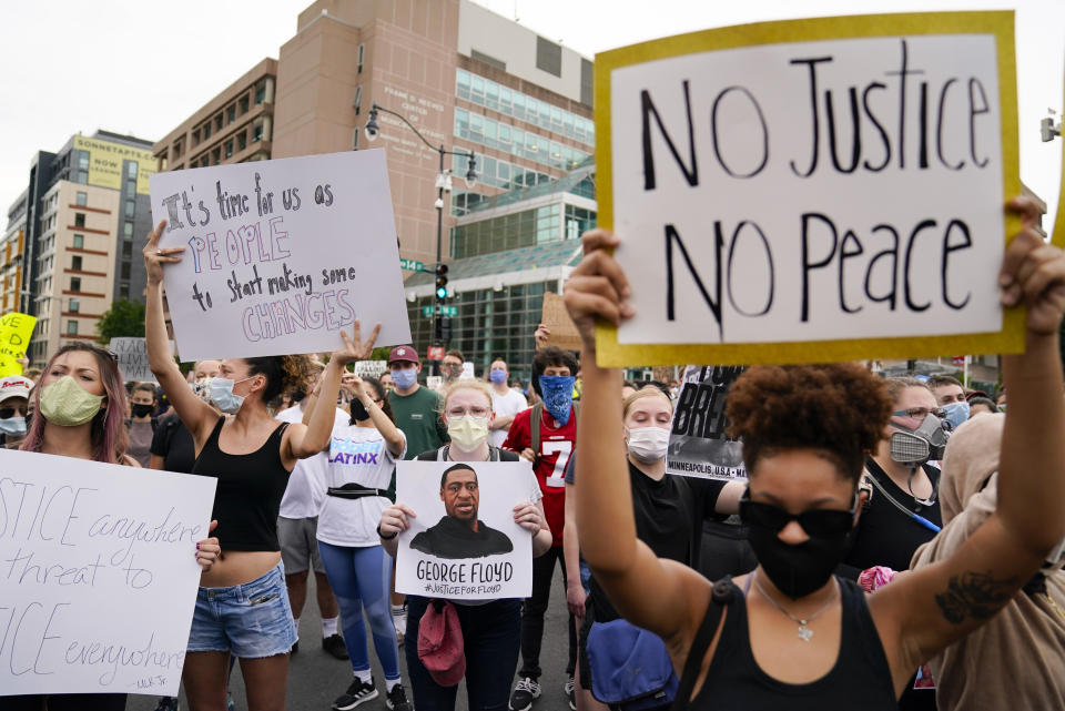 Demonstrators gather to protest the death of George Floyd, a black man who died in police custody in Minneapolis, at the corner of 14th and U streets in Washington, Friday, May 29, 2020. (AP Photo/Evan Vucci)