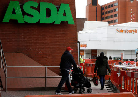 FILE PHOTO: People walk past branches of ASDA and Sainsbury's in Stockport, Britain April 30, 2018. REUTERS/Phil Noble