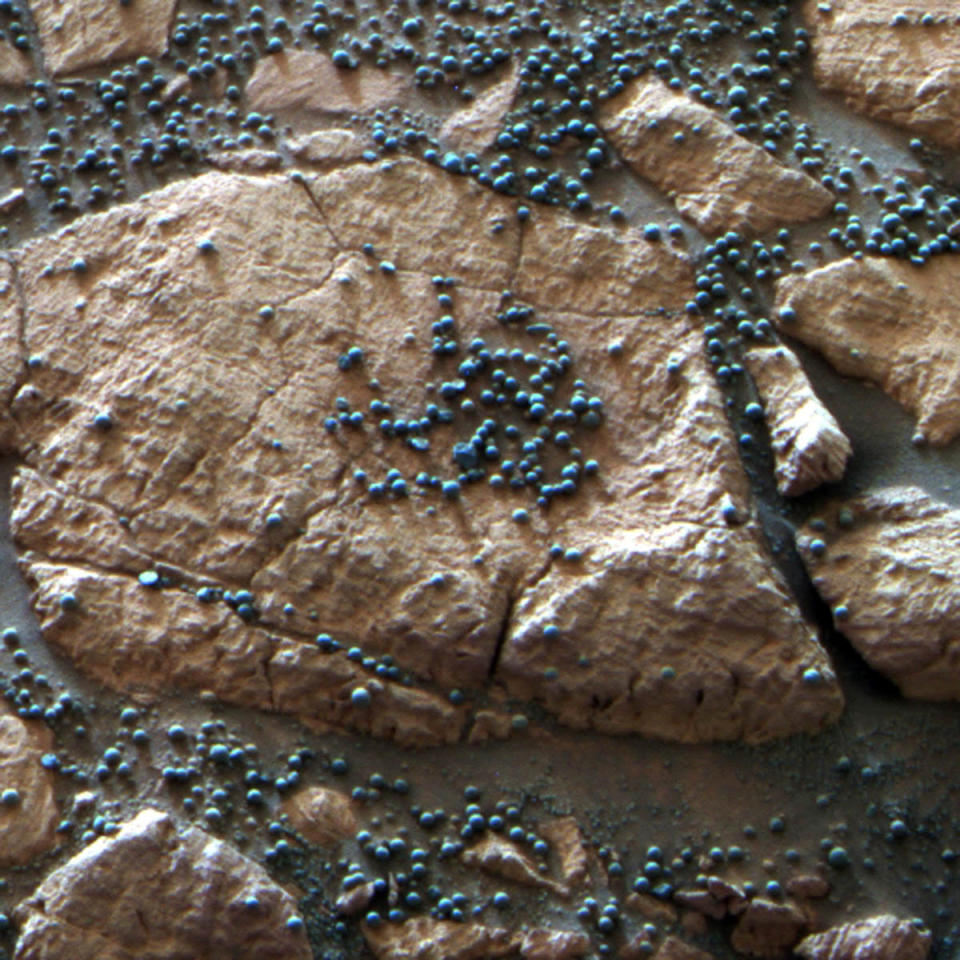 This image provided by NASA shows loose, BB-sized, hematite-rich spherules embedded in this Martian rock like blueberries in a muffin and released over time by erosion. The Mars Rover Opportunity found this cluster of them at its Eagle Crater landing site and analyzed their composition with its spectrometers. Hypotheses about their formation have contributed to the story of water on Mars. Ten years after NASA landed two rovers on Mars on a 90-day mission, one rover is still exploring, and the project has generated hundreds of thousands of images from the Martian surface. Now the Smithsonian’s National Air and Space Museum is presenting more than 50 of the best photographs from the two Mars rovers in an art exhibit curated by the scientists who have led the ongoing mission. (AP Photo/NASA/JPL-Caltech/Cornell University)