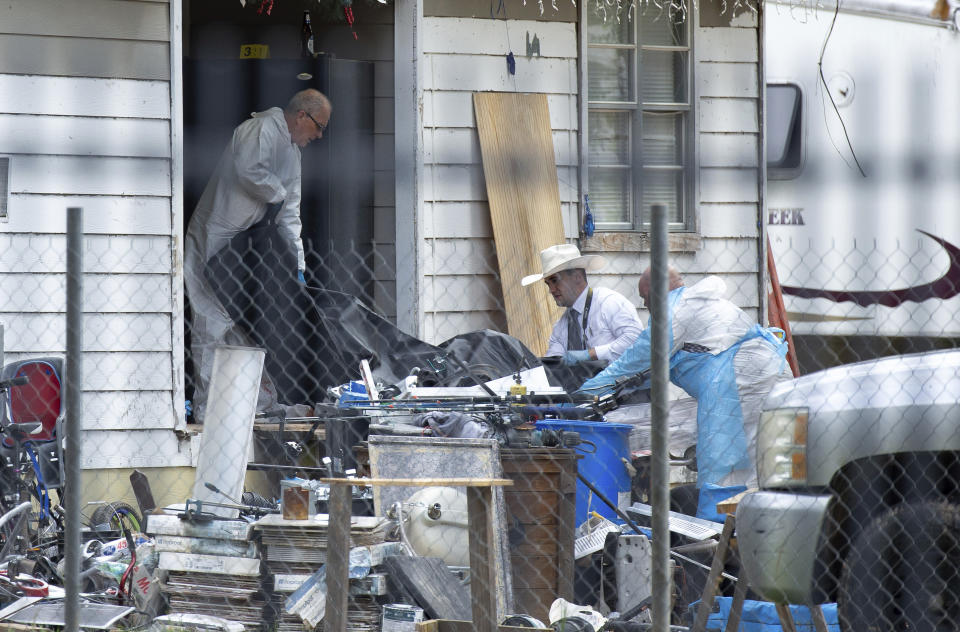 Law enforcement authorities removing bodies from a scene where five people were shot the night before Saturday, April 29, 2023, in Cleveland, TX. Authorities say an 8-year-old child was among five people killed in a shooting at the home in southeast Texas late Friday night. (Yi-Chin Lee/Houston Chronicle via AP)