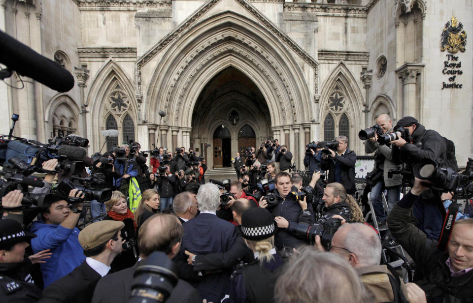 FILE - WikiLeaks founder Julian Assange, center, is surrounded by media, aides and police as he arrives for his hearing at the High Court in London, Nov. 2, 2011. WikiLeaks founder Julian Assange is facing what could be his final court hearing in England over whether he should be extradited to the United States to face spying charges. The High Court will hear two days of arguments next week over whether Assange can make his pitch to an appeals court to block his transfer to the U.S. (AP Photo/Matt Dunham, File)