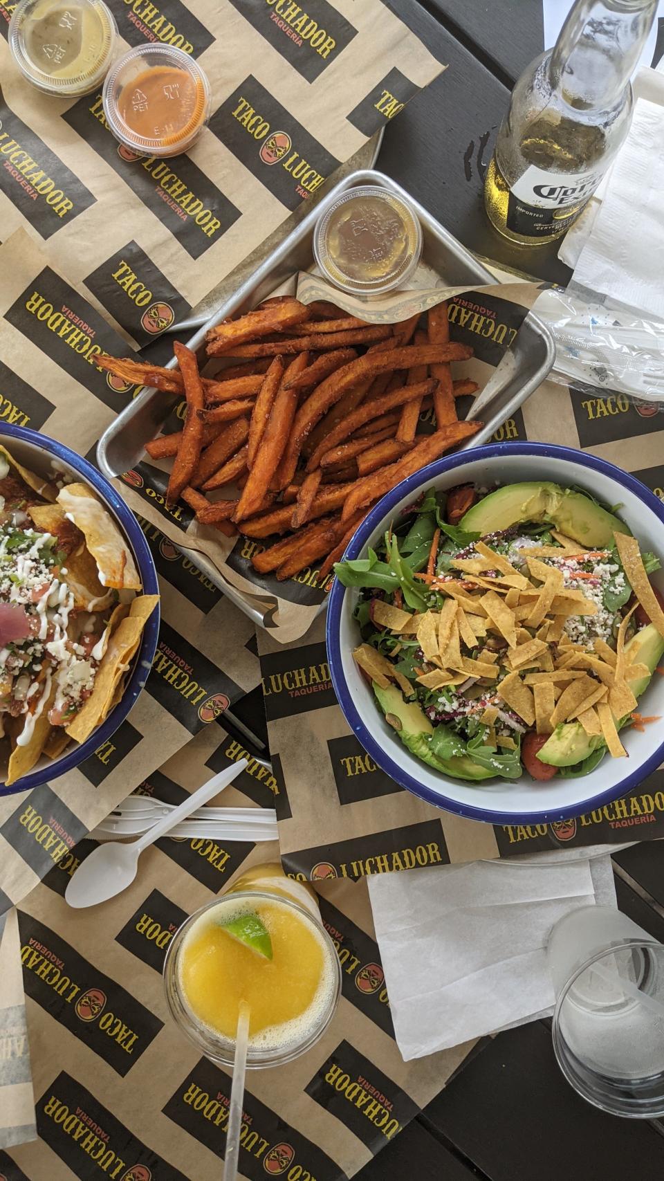 A variety of dishes, including sweet potato fries, at Taco Luchador.