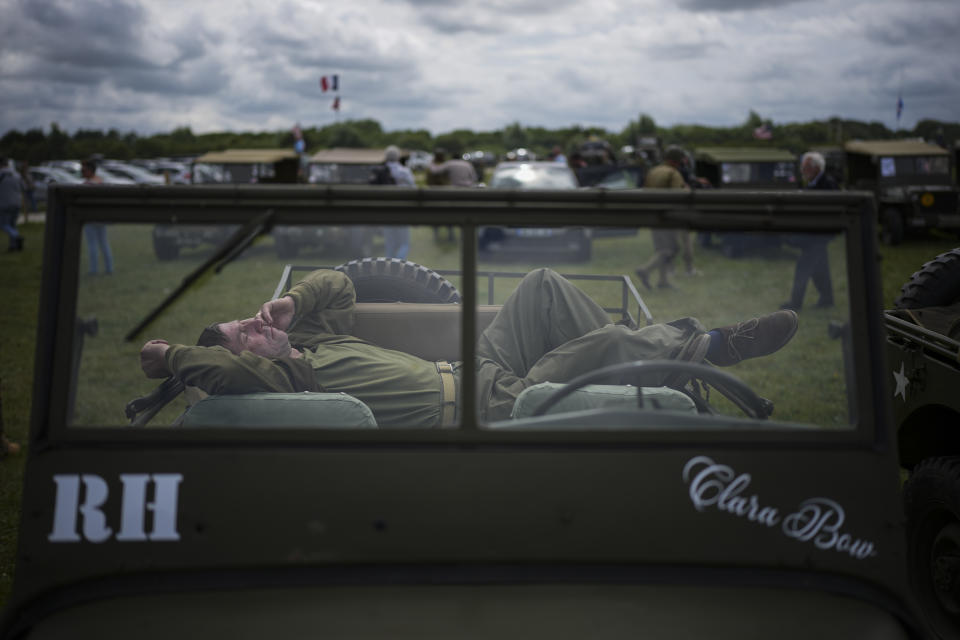 A reenactor sleeps in a vintage US Army jeep at Utah Beach near Sainte-Marie-du-Mont, Normandy, France, Tuesday, June 4, 2024. World War II veterans from across the United States as well as Britain and Canada are in Normandy this week to mark 80 years since the D-Day landings that helped lead to Hitler's defeat. (AP Photo/Daniel Cole)